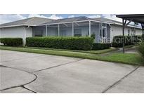 Well-maintained home with a screened-in lanai and manicured hedge landscaping at 1108 Apple Ter, Leesburg, FL 34748