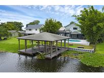 Waterfront home featuring a covered dock with boat lift and direct access to the lake, creating an ideal boater's paradise at 2610 Florence Dr, Kissimmee, FL 34744