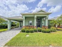 Charming home with a well-maintained lawn, green exterior, and a stylish brick-accented facade at 3021 King Palm Dr, New Smyrna Beach, FL 32168