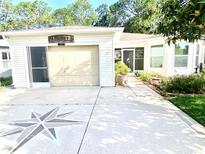 Charming home featuring a one-car garage and a unique compass design in the driveway at 409 Westwood Dr, Leesburg, FL 34748