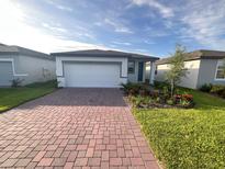 Charming one-story home featuring a brick-paved driveway and well-maintained landscaping at 4957 Kaia Ave, Winter Haven, FL 33884