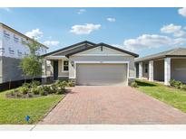 Charming one-story home featuring a brick driveway and two-car garage, beautifully landscaped at 4973 Kaia Ave, Winter Haven, FL 33884