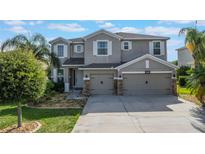Charming two-story home with a well-maintained lawn, three-car garage, and beautiful landscaping at 637 Neptune Dr, Groveland, FL 34736
