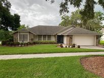 Charming single story home with a well maintained front yard and an attached two car garage at 724 Rosemere Cir, Orlando, FL 32835