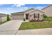 Charming single-story home with a well-manicured front yard, two-car garage and a welcoming front entrance at 733 Citrus Reserve Blvd, Davenport, FL 33837