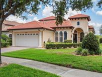 Stunning home featuring a barrel tile roof, arched windows and manicured landscaping at 9335 San Jose Blvd, Howey In The Hills, FL 34737