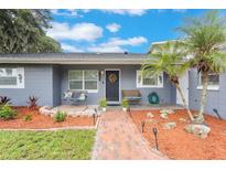 Charming front entrance with a beautiful wreath, cozy benches, and landscaped garden beds creates a warm and inviting welcome at 11750 Watts Ct, Tavares, FL 32778