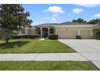 Attractive single-story home featuring a well-manicured lawn and a three-car garage at 1426 Lakemist Ln, Clermont, FL 34711