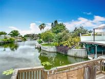Picturesque waterfront view of a serene canal with lush landscaping and private docks on a sunny day at 1611 Canal, Tavares, FL 32778