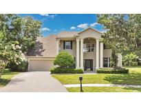 Stately two-story home featuring classic columns and a well-manicured front lawn at 17300 Summer Sun Ct, Clermont, FL 34711