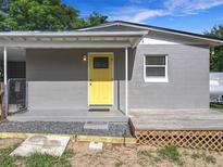 Charming home with a bright yellow front door, gray siding, and a cozy porch at 326 N Lancelot Ave, Orlando, FL 32835