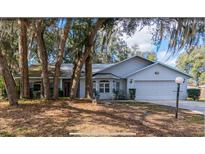 Charming single-story home with mature trees and a well-maintained lawn at 35219 Haines Creek Rd, Leesburg, FL 34788