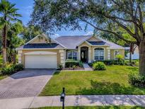 Charming single-Gathering home with a brick driveway, lush lawn, and mature landscaping at 359 Blue Branch St, Eustis, FL 32736