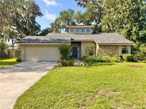 Charming single-story home with stone accents, lush lawn, mature trees, and a two-car garage at 3664 Se 45Th Pl, Ocala, FL 34480