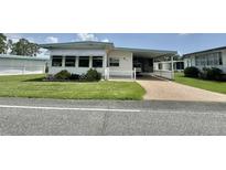 Charming single-story home with well-maintained lawn, white picket fence, and covered carport at 424 Hawthorne Blvd, Leesburg, FL 34748