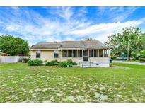 Charming single-story home with a screened porch and a well-maintained front yard at 520 Dora Ave, Tavares, FL 32778