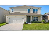 Charming two-story home with a well-maintained lawn and attached two-car garage at 5386 Pine Lilly Dr, St Cloud, FL 34771
