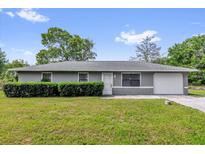 Charming one-story home with a well-manicured lawn and mature landscaping at 5390 Nw 12Th Pl, Ocala, FL 34482