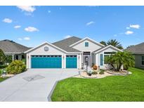 Charming single-story home with a three-car garage and well-manicured lawn and attractive landscaping at 5746 Botner Dr, The Villages, FL 32163