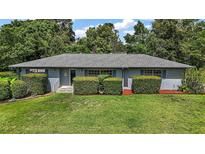 Charming single-story home featuring a well-maintained lawn and carefully trimmed hedges and mulch at 902 Lakeview Dr, Eustis, FL 32726