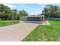 Charming home featuring a screened-in porch and spacious driveway, set amidst lush greenery at 10161 Sw 87Th Ter, Ocala, FL 34481