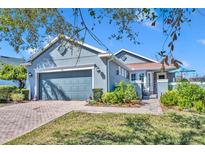 Charming single-story home with a well-manicured lawn, brick walkway, and attached two-car garage at 109 Falling Acorn Ave, Groveland, FL 34736