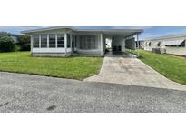 Charming single-story home featuring a covered carport and well-maintained lawn at 112 Caladium St, Leesburg, FL 34748