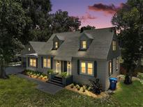 Charming two-story home with dormer windows, manicured lawn, and inviting front entrance at dusk at 126 E Beach St, Groveland, FL 34736