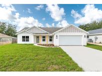 Charming single-story home featuring a manicured lawn and a two-car garage at 13334 Sw 107Th St, Dunnellon, FL 34432