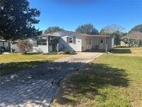 Charming home with brick driveway and lovely landscaping, inviting curb appeal at 1404 Plantation Dr # 9, Lady Lake, FL 32159