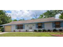 Charming single-story home featuring light blue siding and well-maintained landscaping at 235 Rockmoore Ct, Deland, FL 32720