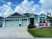 Charming single-story home with two-car garage, manicured lawn, and welcoming front porch area at 2648 Maymont Ct, The Villages, FL 32163