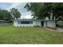 Charming single-story home featuring a well-maintained lawn and freshly painted exterior with dark trim at 2961 Northland Rd, Mount Dora, FL 32757