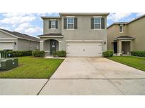 Two-story home featuring a two-car garage, neutral gray paint and minimalist landscaping in a suburban neighborhood at 30422 Pintail Dr, Leesburg, FL 34748