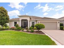 Charming single-story home featuring manicured lawn, flowerbeds and a screened entrance way at 4210 Arlington Ridge Blvd, Leesburg, FL 34748