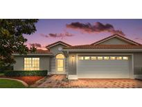 Charming single-story home with a red tile roof, brick driveway, and manicured landscaping at 5071 Harbour Dr, Oxford, FL 34484