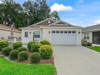 Charming single-story home with a two-car garage, tidy landscaping and a welcoming entrance at 5719 Spartina Ter, The Villages, FL 32163