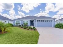 Charming single Gathering home boasting a well maintained lawn, mature plantings and a two car garage at 6949 Minchew Cir, The Villages, FL 34762