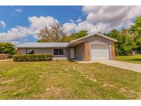 Charming single-story home featuring stone accents, a metal roof, and a well-maintained front lawn at 7211 Se 120Th St, Belleview, FL 34420