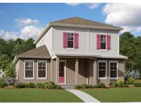 Charming two-story home featuring pink shutters and a welcoming covered front porch at 10288 Fiddley Aly, Orlando, FL 32827