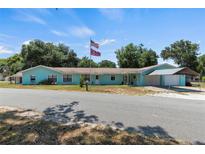 Charming single story home with a covered attached carport and manicured lawn at 1048 Cr 452A, Lake Panasoffkee, FL 33538