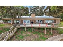 Charming brick home featuring a spacious deck with scenic views and lakeside access at 13033 Se 158Th Ln, Weirsdale, FL 32195