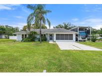 Charming single-story home with well-maintained lawn, mature landscaping, and spacious driveway at 135 N James Pl, Groveland, FL 34736