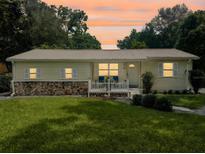 Charming single-story home with well-maintained lawn and front porch seating under a beautiful sunset sky at 1537 Ne 22Nd St, Ocala, FL 34470