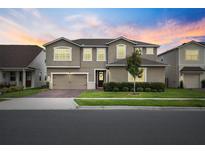 Charming two-story home boasts a well-manicured lawn and a welcoming front entrance at 3304 Canna Lily Pl, Clermont, FL 34711