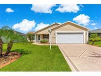 Charming single-story home with a well-manicured lawn, decorative driveway, and attached two-car garage at 362 Arbella Loop, The Villages, FL 32162