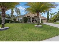 Beautiful home featuring a well-manicured lawn and lush landscaping with palm trees at 4018 Chandler Estates Dr, Apopka, FL 32712