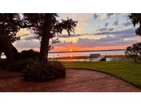 Scenic waterfront view featuring a tranquil lake and stunning sunset at 504 Banning Beach Rd, Tavares, FL 32778