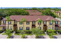 Inviting townhome exterior featuring a well-maintained lawn and lush landscaping at 624 Terra Lago St, Davenport, FL 33897