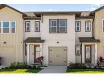 Charming townhouse with neutral siding, a one-car garage, and well-manicured landscaping at 709 Longboat Dr, Davenport, FL 33896